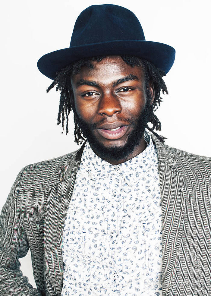 年轻帅气的美国黑人男孩戴着时髦的时髦帽子在白色背景下微笑着表示