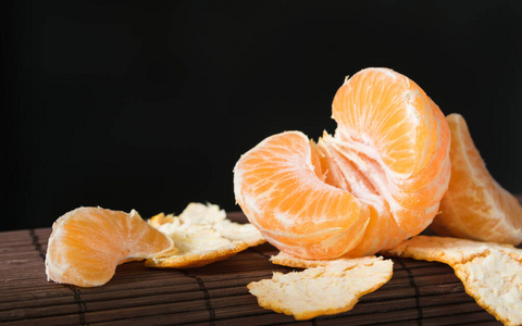 静物，黑色背景下的成熟多汁的柑橘片特写镜头
