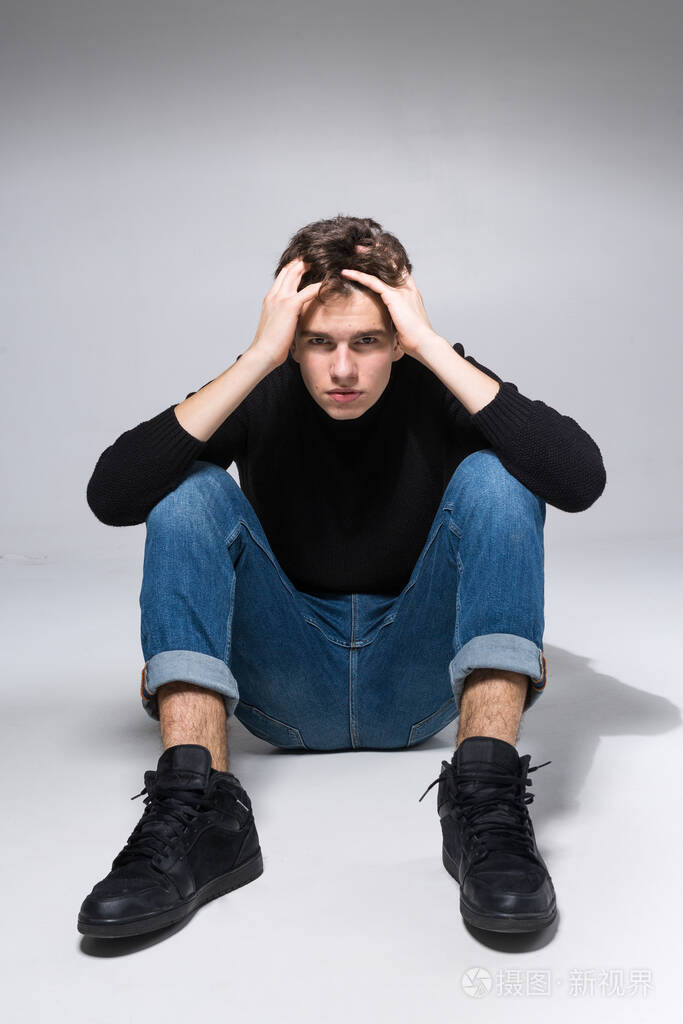 摄影棚拍到英俊迷人的欧洲男人坐在地板上