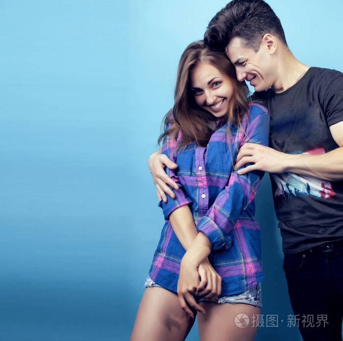 幸福的情侣在蓝色的背景下摆出欢快的姿势男生和女生一起做朋友