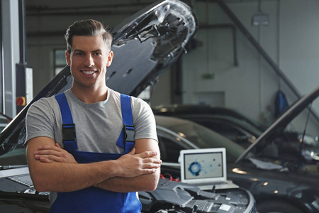 Mechanic near automobile in service center, space for text. Car 