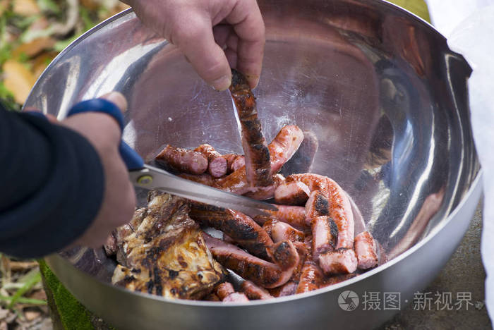 切香肠和烤肉的男人