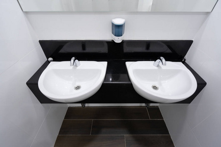 现代水龙头和白色陶瓷洗手盆水槽浴室内部