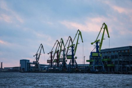 Port view of multiple big shipping cargo cranes. 