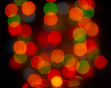 散焦模糊灯泡，圆透镜喇叭装饰。背景背景设计红黄绿。圣诞花环与模糊发光闪亮的灯光