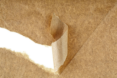 Holes in brown paper with torn sides over paper background with 