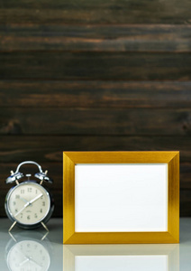 Mockup with golden frame and alarm clock 