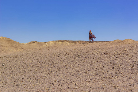 孤独的单身女性肖像在多风的天气里飘动的衣裳和头发在以色列沙漠荒原