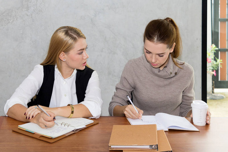 Two women are studying and teaching 