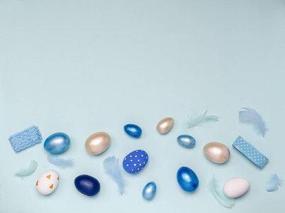 复活节彩蛋，蓝色调，蓝色羽毛和丝带，蓝色背景，可供复制空间。