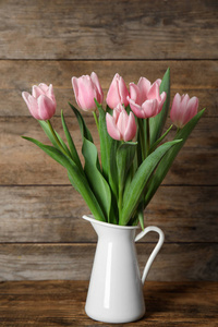 木桌上花瓶里美丽的粉红色郁金香