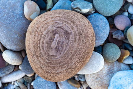 海岸上的鹅卵石.褐色圆形花纹石头.不同大小和颜色的石头.照片