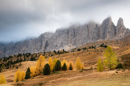 Dolomite mountain peaks covered in fog during sunrise 