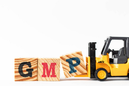 玩具叉车手持木制字母块P，以完成单词GMP良好生产规范的缩写在白色背景上