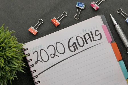 2020 new year goal on notepad with pen on table 