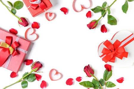 心形礼品盒和带有心形红丝带和玫瑰花瓣的红玫瑰