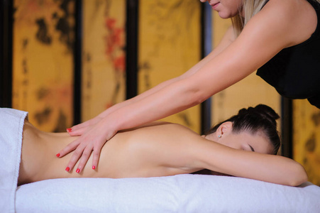 Masseur applying beauty massage on a female client Lateral view 