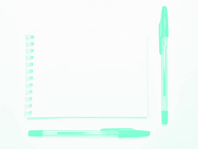 白桌上用笔打开笔记本纸，复印空间。薄荷水