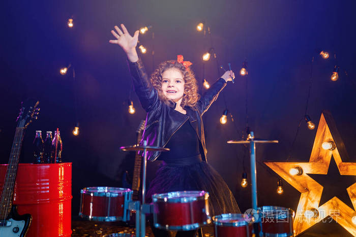 在黑色背景上打鼓的漂亮女孩