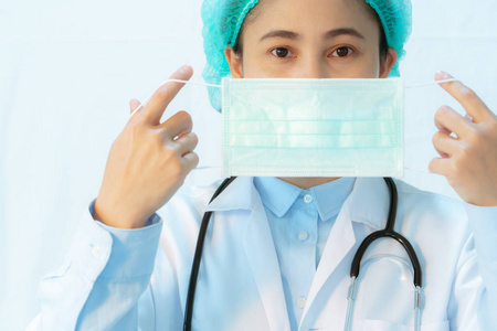 年轻女医生戴口罩听诊预防传染病和流感.医疗保健理念照片