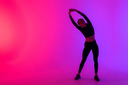  young athlete on a bright background flexes before training