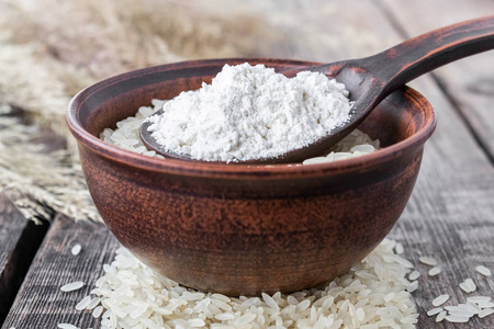 全麦粉含量至少是多少碗里放着白米,碗里放着一勺白面,背景是旧木板.