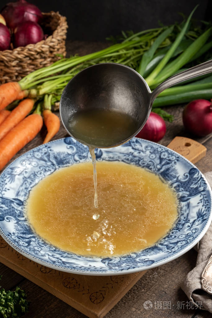 把鸡骨汤倒进老式盘子里