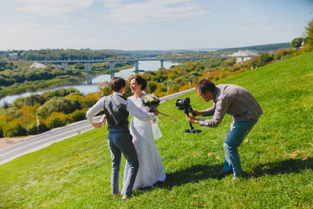 婚礼摄影师在山坡上为新郎新娘拍照照片