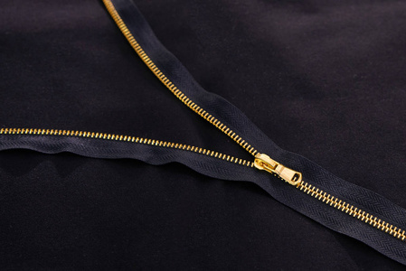 背景为黑色织物上的金色拉链