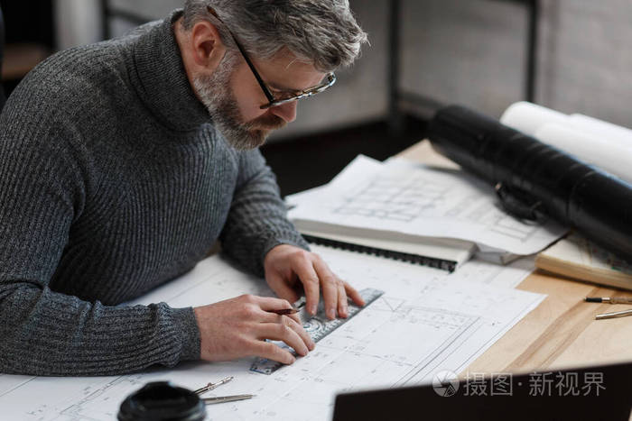 建筑师在办公室绘制蓝图.绘制建筑工程草图的工程师.建筑平面图.