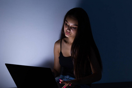 悲伤的女性青少年，带着平板电脑和笔记本电脑，遭受网络欺凌和骚扰，在网上被跟踪者或八卦者虐待，在网络欺凌中感到绝望和羞辱。