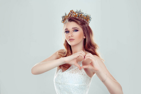 美丽浪漫的少女,头戴水晶冠,用手指做一个心形手势,表达对他人的关爱.