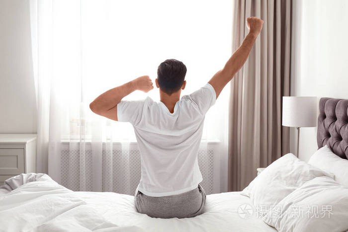 男人在家里在床上醒来懒散的早晨