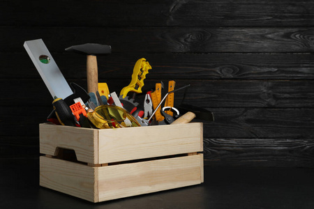 黑桌子上放着不同木工工具的木箱。服务提供商