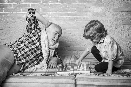国际象棋。童年。国际象棋比赛。几代人。象棋爱好爷爷和孙子下棋。