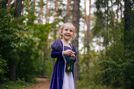 一个穿着紫色中世纪礼服的白发小女孩坐在一棵树上,树上有一盏灯.