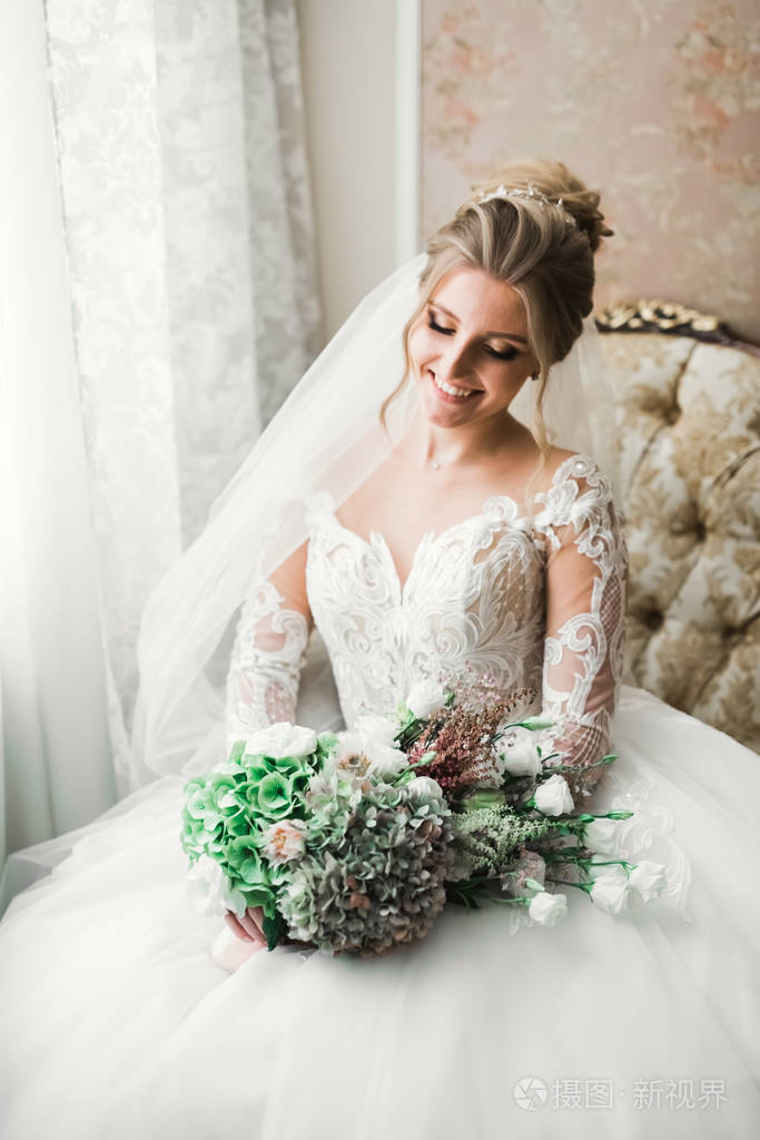 身着白色礼服的豪华新娘在准备婚礼时摆姿势