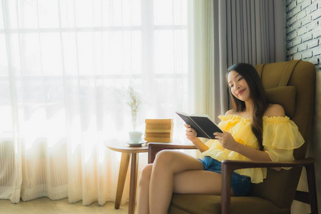 Portrait young asian woman sit on sofa chair and read book with 