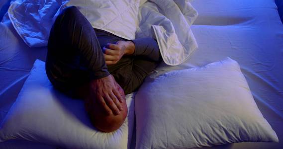 他睡着了,辗转反侧,抱着头.照片