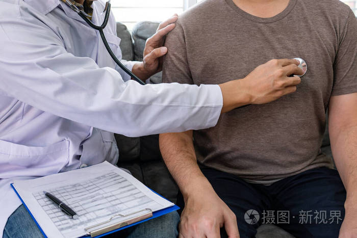 医生在医院的办公室里用听诊器听兴高采烈的年轻病人的胸脯