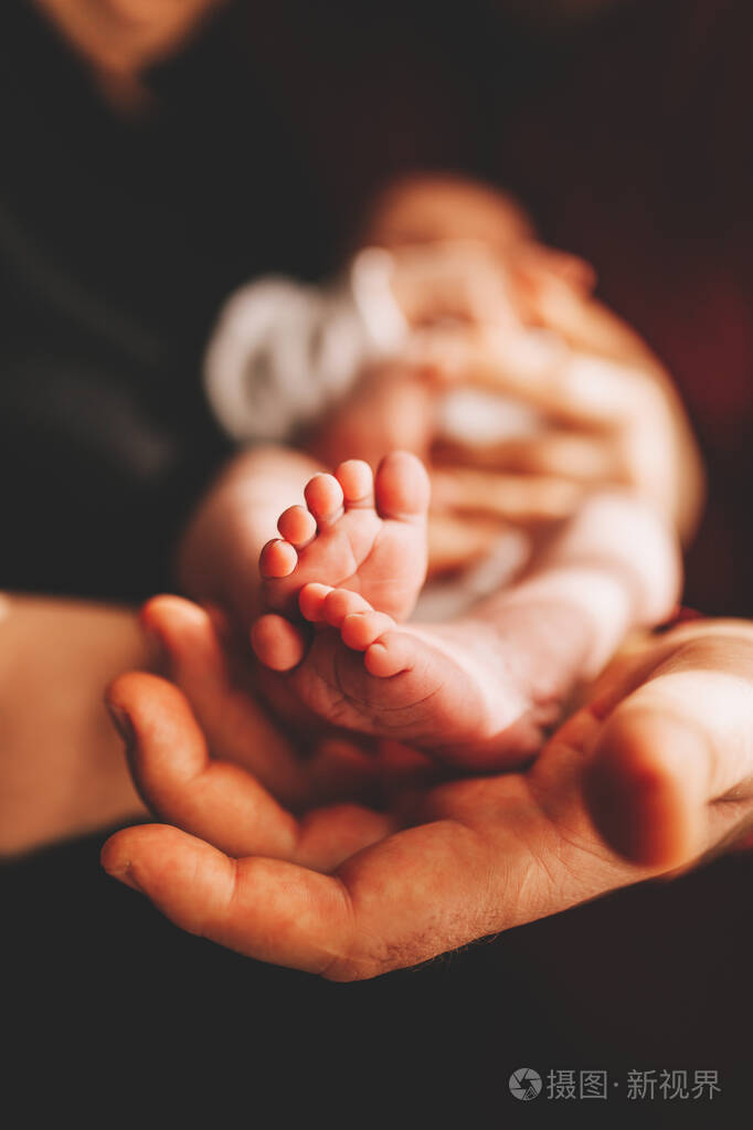 小婴儿的脚放在女性形状的手上特写.妈妈和她的孩子.幸福家庭理念.