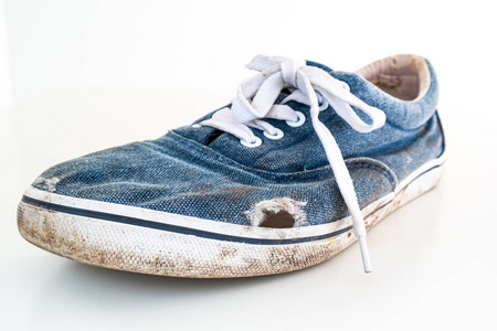 休闲鞋特写搭配或非常破旧的脏蓝色休闲鞋照片