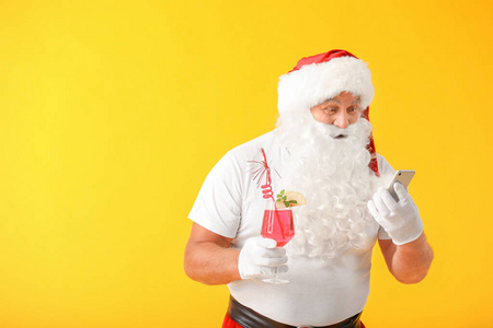 圣诞老人鸡尾酒和手机的彩色背景。度假的概念