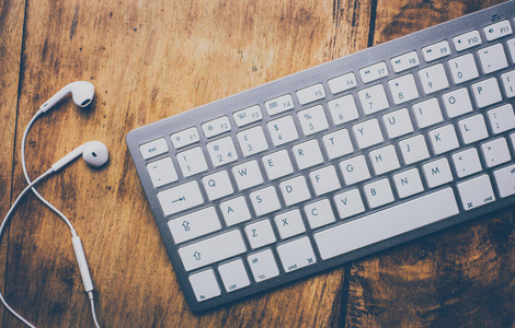 Wooden  desk table with laptop computer, earphones. Retro 