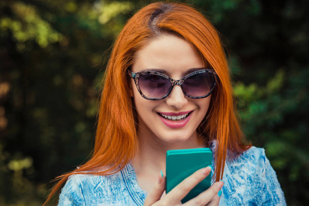 Sms. Young red head Woman in blue jeans texting looking talking 