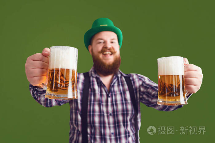 圣帕特里克节快乐一个戴着绿帽子的胖子举着啤酒