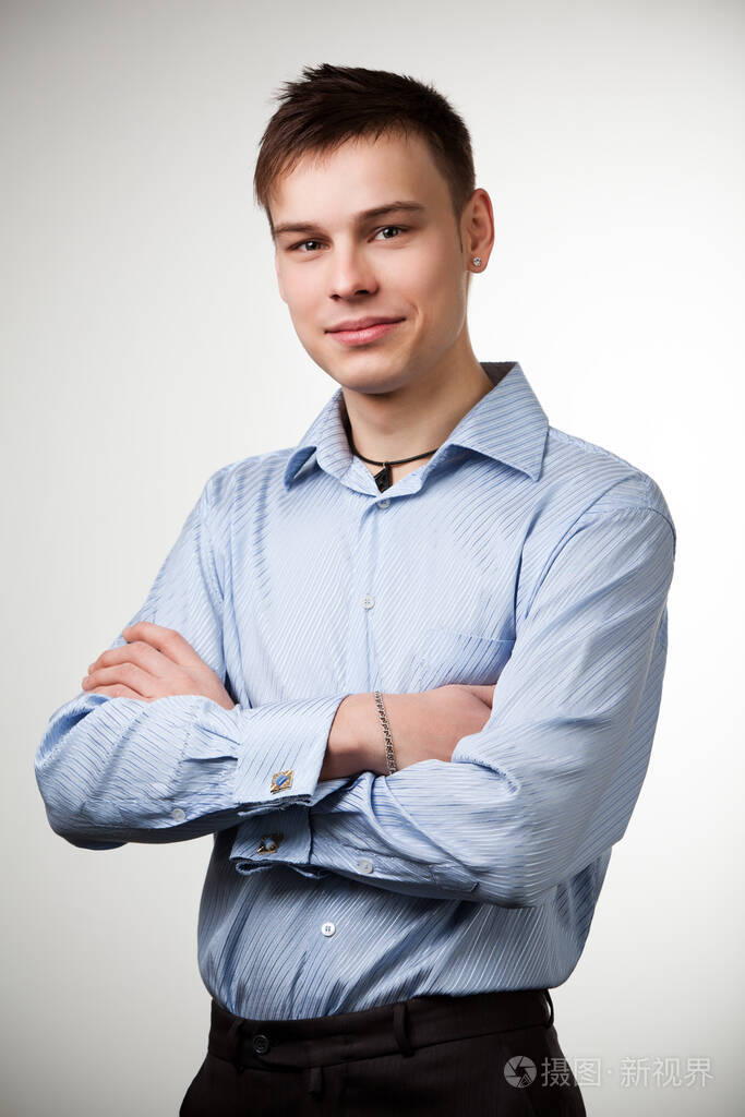 一个穿蓝色衬衫的人双臂交叉放在胸前