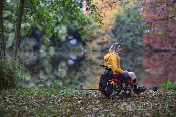 一个没有腿的残疾妇女坐在轮椅上。