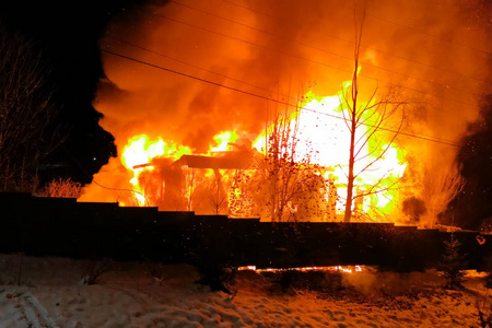 房子着火了,一个村庄的房子着火了,消防队员扑灭了照片