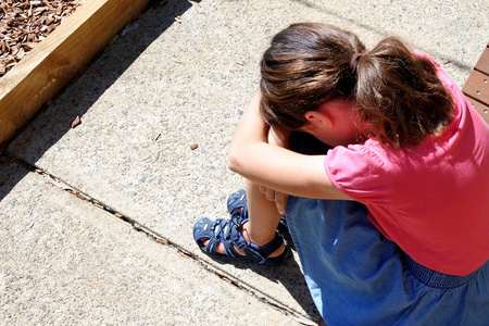 伤心的小女孩在校园里捂着脸哭图片